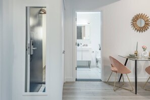 Ein modernes Badezimmer mit Waschbecken, Spiegel und Toilette in Weiß.