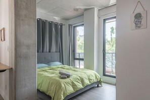 Ein Schlafzimmer mit Bett, Vorhängen, einem Fenster und einer Wanddekoration.