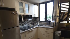Una cucina moderna con frigorifero in acciaio inossidabile, microonde, lavello e macchina del caffè.