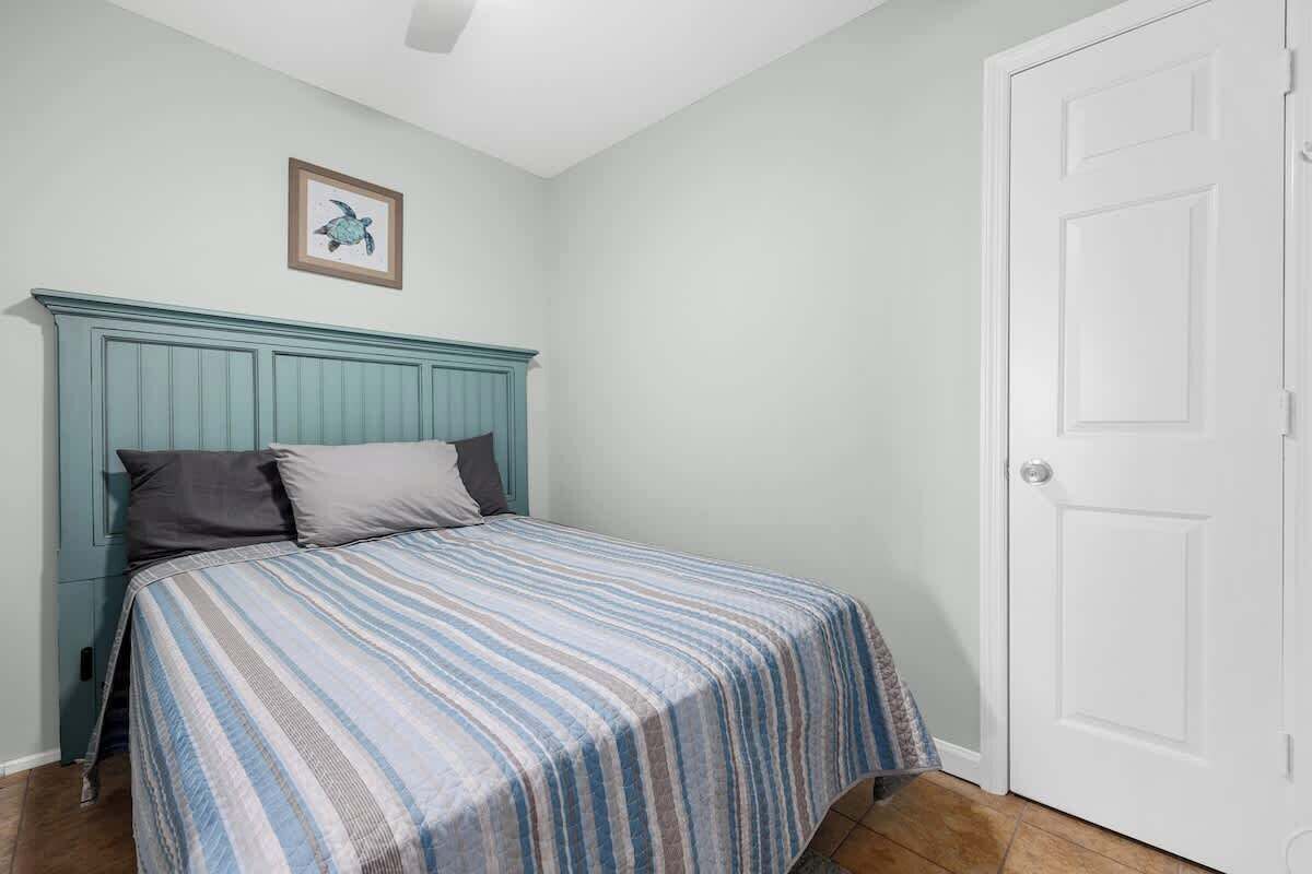 Una camera da letto con un letto, una porta e un quadro appeso al muro.