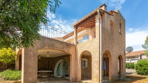 A stone building with arched walkways, a balcony, and a satellite dish. - La Maison de Valérie: Charming Provençal House Near the Beach for 6 Guests (La Croix-Valmer)