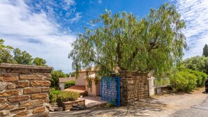 A stone wall, a blue gate, and a tree in front of a building. - La Maison de Valérie: Charming Provençal House Near the Beach for 6 Guests (La Croix-Valmer)