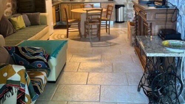 A cozy interior with a stone wall, wooden ceiling, a dining area, and a sofa. - Nine - PEYRIAC DE MER (PEYRIAC DE MER)