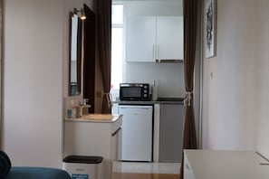 A compact kitchenette with a microwave, a small fridge, and a sink. - Villa Alta Vista (Sao Jorge)