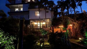 A multi-story building with balconies and a well-lit entrance. - Villa Alta Vista (Sao Jorge)