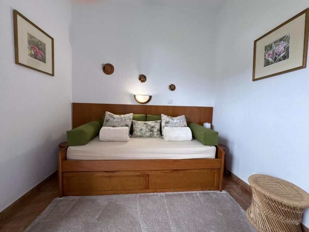 A bedroom with a wooden bed, a small round table, and two wall-mounted light fixtures.