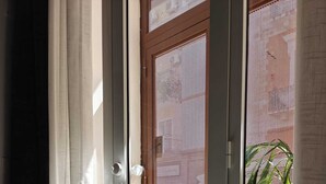 Ein Zimmer mit einer Schiebetür und einem Balkon, der einen Stuhl und eine Pflanze bietet.