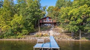 A lakeside cabin with a dock, surrounded by trees. - The Lakeside Lookout - Lakefront 4BR Cabin - Dock, Kayaks, Swim Raft + Game Shed (Cushing)