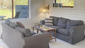 A living room with a sofa, armchair, and a glass coffee table. - 3 bedroom lovely home in Sjællands Odde (Sjællands Odde)