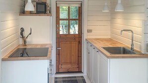 A compact kitchen with a wooden door, two sinks, a microwave, and a small window. - 3 bedroom lovely home in Sjællands Odde (Sjællands Odde)