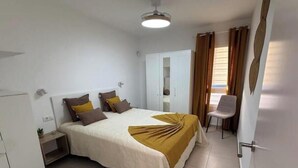 Une chambre à coucher comprenant un lit, une table de chevet, une armoire et une chaise.