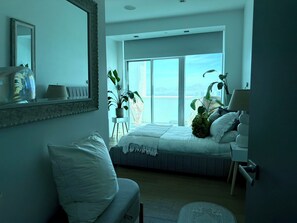 A bedroom with a bed, a chair, a desk, a mirror, and a view of the outdoors. - Spacious 3-bedroom condo in amazing Las Vegas with AC and gym (Las Vegas)