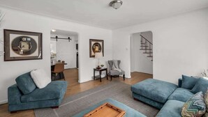 A spacious living area with two sofas, a coffee table, and framed artwork on the walls.
