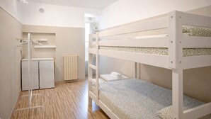 A bunk bed room with a small desk, radiator, and a coat rack. - Vacation House - A Ridosso dei Sassi (Matera)