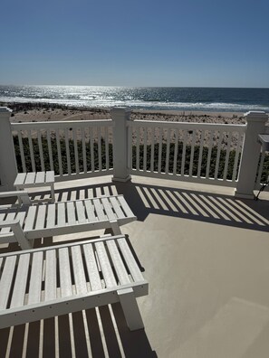 A beachside patio with white railings, a table, and chairs. - Perfect Oceanfront Home with 5 Bedrooms in ideal Surf City with Central AC. (Surf City)