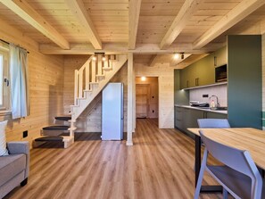 A wooden interior with a staircase, a refrigerator, a dining table, and a kitchen area. - Kemp Stříbrný rybník by Interhome (Hradec Kralove)