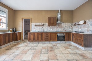 A kitchen with wooden cabinets, a built-in oven, and a patterned backsplash. - Apartment 'Hacienda El Legado 5' with Shared Pool, Wi-Fi and Air Conditioning (Chiclana de la Frontera)