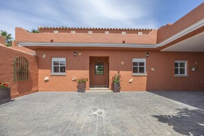 Un edificio con entrada de baldosas, una puerta y dos ventanas.