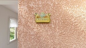 Una pared con textura y un cartel que dice 'LE TENNI'.