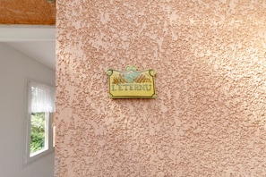 Eine strukturierte Wand mit einem Schild, auf dem 'LE TENNI' steht.
