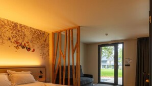 A hotel room with a bed, a wooden partition, a sofa, and a view of the outdoors. - Hotel La Reposee Rest. L'escu De Runfao (Liffre)