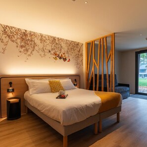 Un dormitorio moderno con una cama grande, cabecera de madera, luz de pared y vistas al exterior.