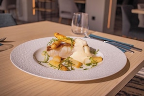 A plate of food on a table with a glass of water and cutlery. - Hotel La Reposee Rest. L'escu De Runfao (Liffre)