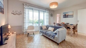 Un salon moderne avec un canapé, une table à manger et un téléviseur.