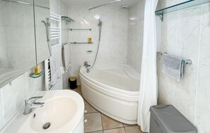 A bathroom with a bathtub, a sink, and a shower. - Maison à la Cotinière (Saint-Pierre-d'Oléron)