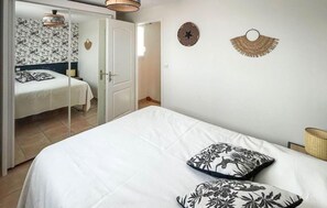 Ein Schlafzimmer mit einem Bett, einem Kleiderschrank und einem Spiegel.
