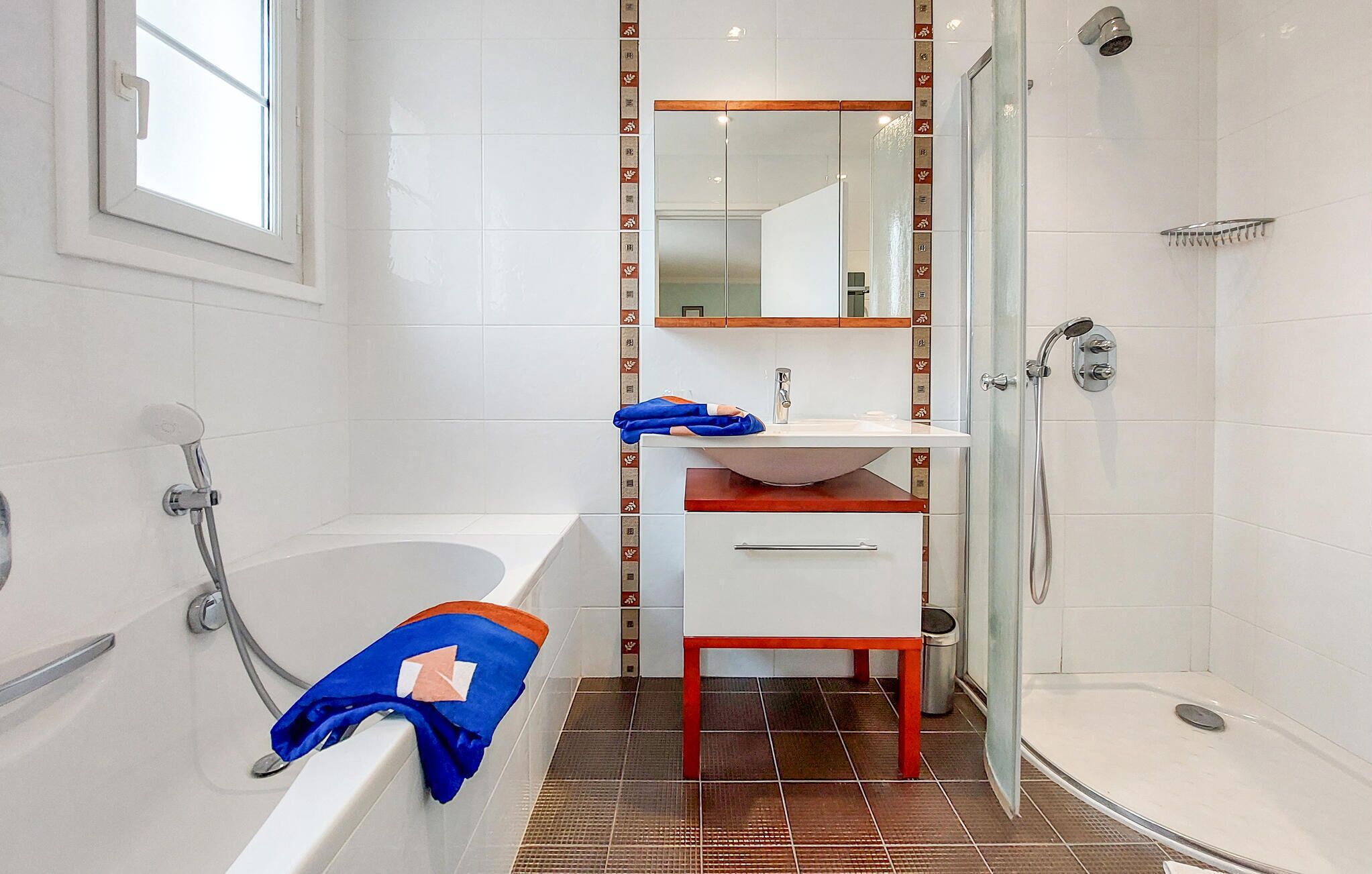 A modern bathroom with a bathtub, a shower, and a sink.