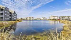 Un quartier résidentiel avec un plan d’eau, des immeubles dotés de balcons et un ciel dégagé.