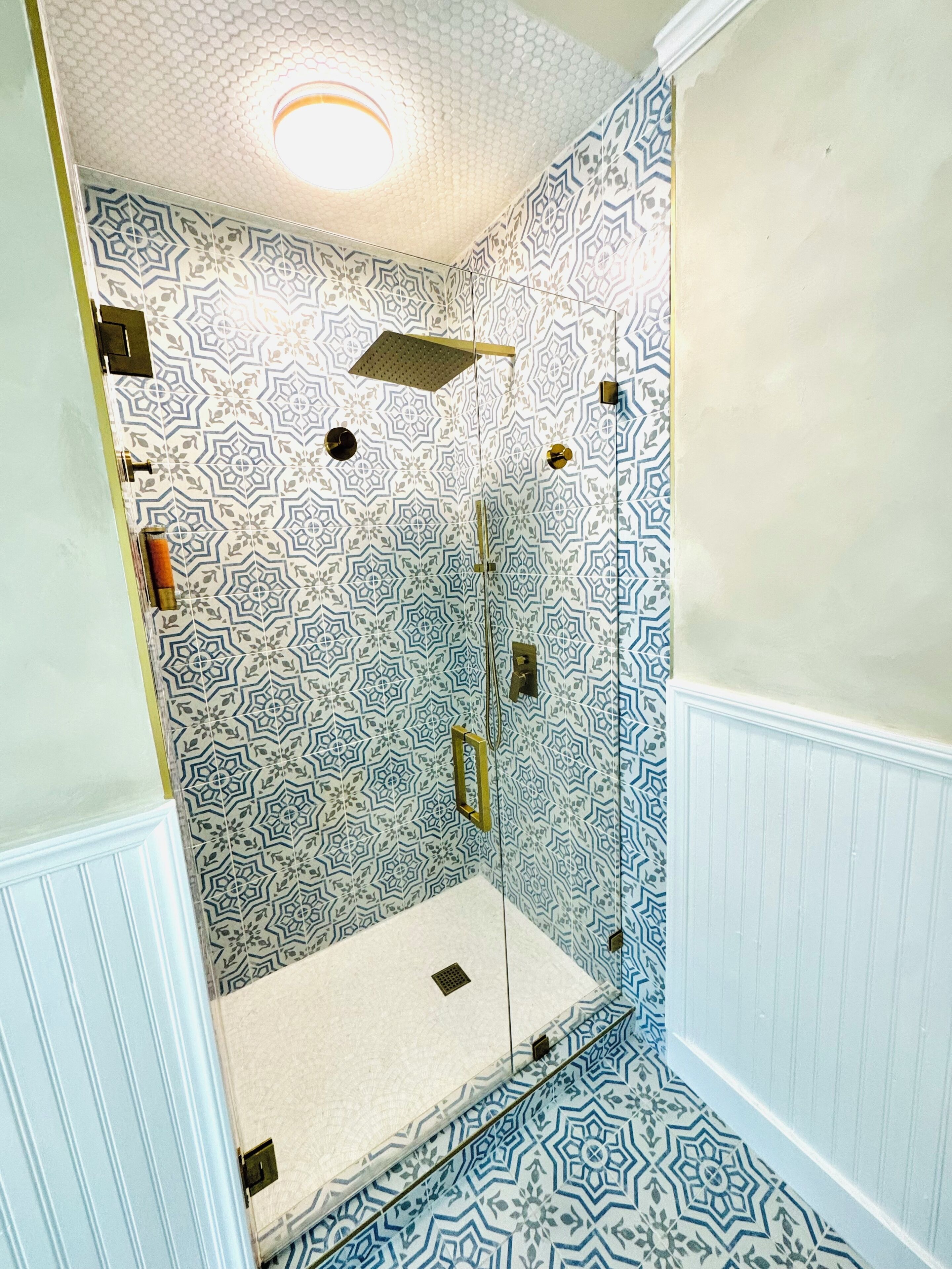 Une salle de bain avec des murs à motifs, une douche et des toilettes.