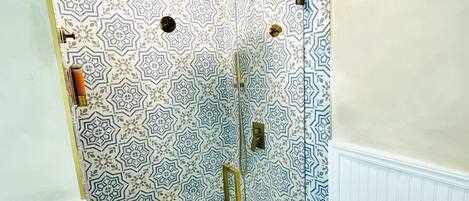Une salle de bain avec des murs à motifs, une douche et des toilettes.