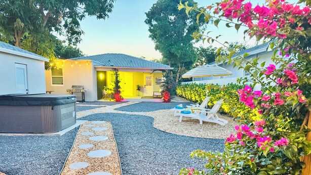 Un patio con jacuzzi, sillas de descanso y un sendero con piedras circulares.