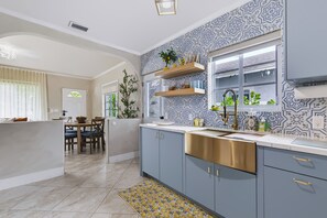 Una cocina moderna con una isla central, pileta integrada y un salpicadero con diseño.