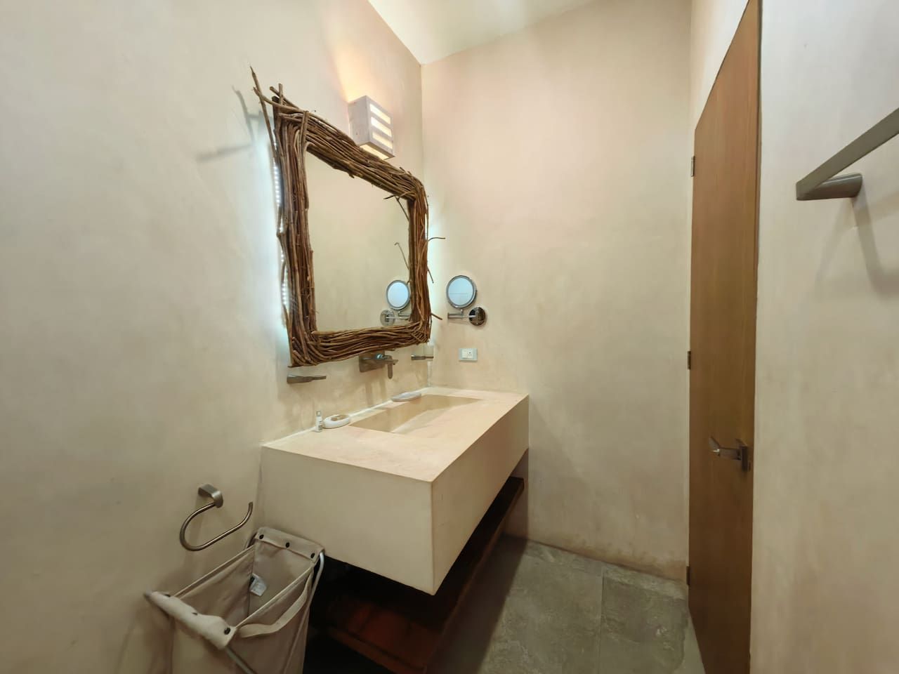 A bathroom with a large mirror, a sink, and a towel rack.
