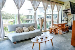A living room with a sofa, a coffee table, and a TV stand. - Boho Loft Pool Priv Sillas Colgantes- Centro Tulum (Tulum)