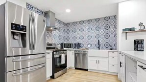 A modern kitchen with stainless steel appliances, a microwave, and a coffee maker. - Desert Rose Retreat (Joshua Tree)