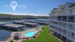 Un hôtel à plusieurs étages doté d’une piscine, de bateaux amarrés et offrant une vue sur un lac.