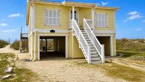 Un bâtiment jaune à deux étages, doté d’un escalier blanc, d’une entrée couverte et d’une enseigne portant le numéro « 125 ».