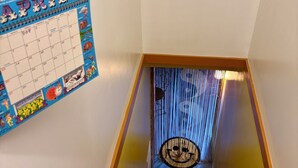 A staircase with a clock and a calendar on the wall.