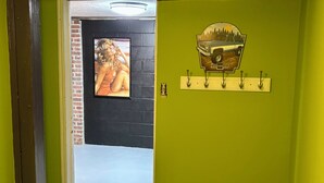 A room with a green wall, a door with a coat rack, and a poster of a pickup truck.