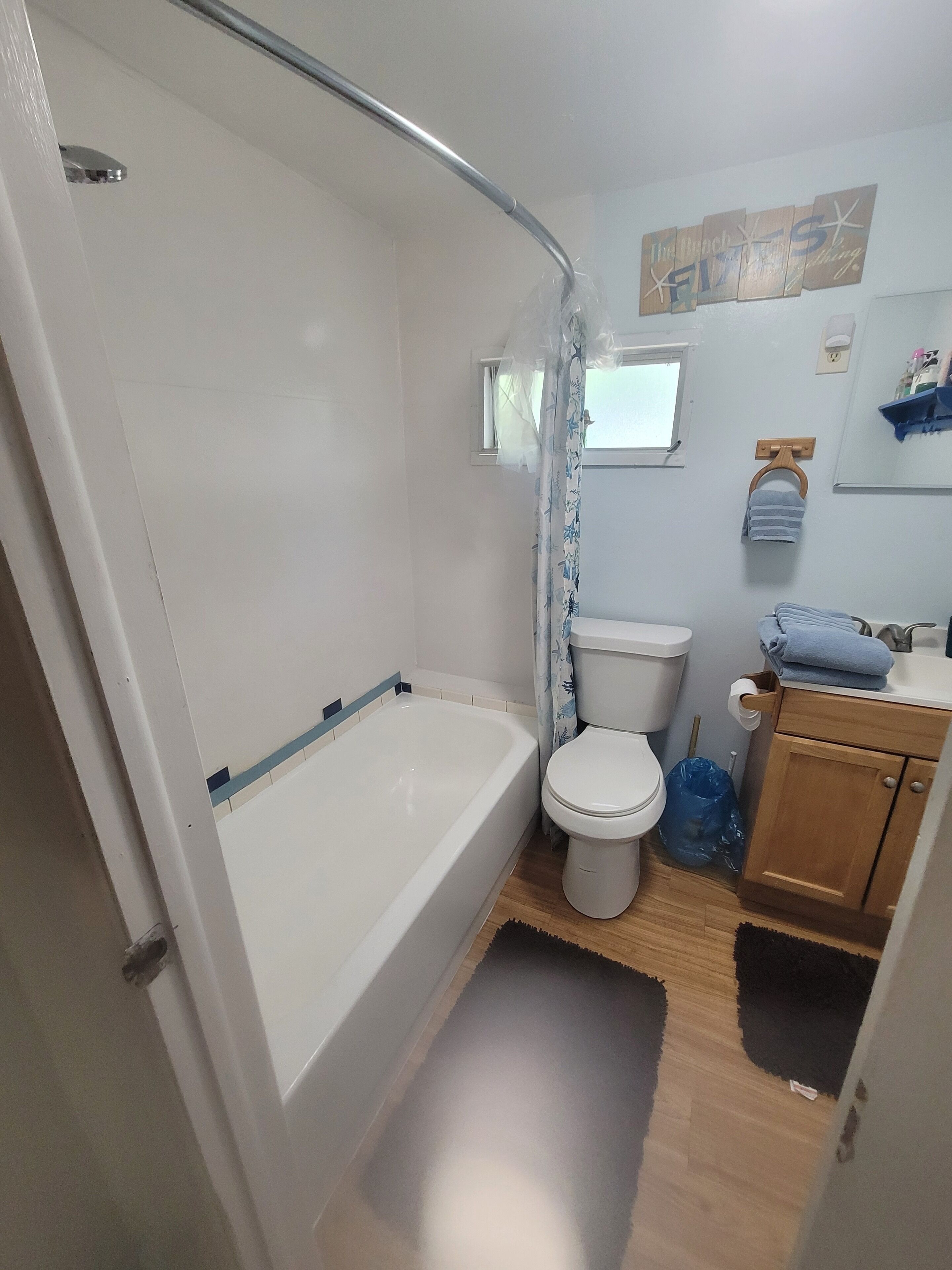 Une salle de bain avec une baignoire, des toilettes et un rideau de douche.