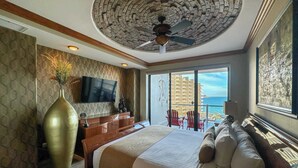 A spacious bedroom with a large bed, a ceiling fan, a TV, and a balcony with a view of the ocean. - The Iconic Beachfront 3BR Condo (Puerto Peñasco)