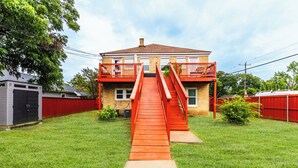 A two-story house with a red staircase leading to a balcony. - Historic Oak Cliff Retreat - Yoga & Wellness Room Near Bishop Arts (Dallas)