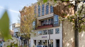 Un edificio de varios pisos con escaparate que dice 'LOREM' y un balcón visible.