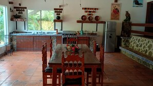 Una cocina amplia con una mesa de comedor de madera, sillas y una isla central.