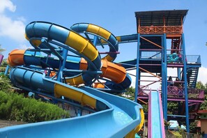 Een waterglijbaan met meerdere banen, een controle toren en een platform met trappen.