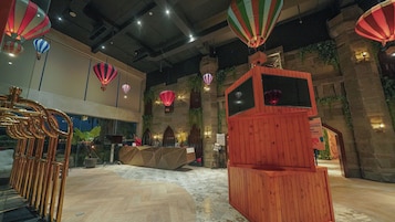 Un interior moderno con una recepción, globos aerostáticos y una estructura de madera original.